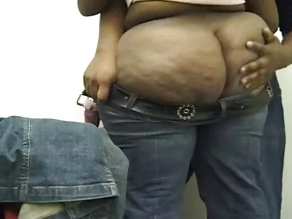 Msichana mrembo xxx wa Kiafrika mwenye punda mweusi akisaidiwa kuvaa suruali yake ya jeans.